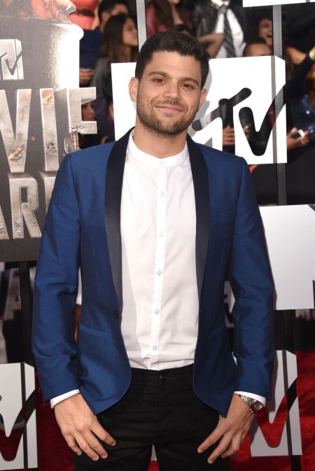 Jerry Ferrara in a blue coat poses at an MTV event.
